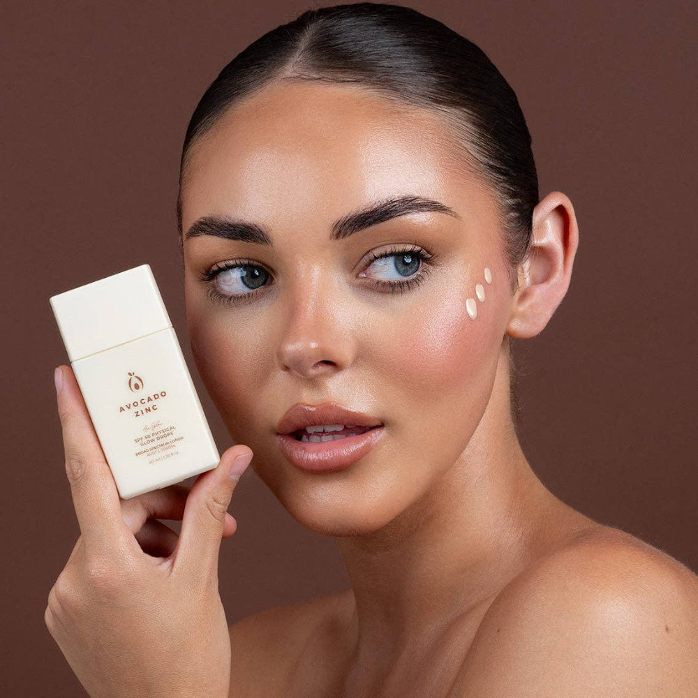 Woman holding a skincare product with a brown background